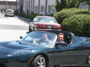 arnold-schwarzenegger-lai xe Tesla Roadster cùng Elon Musk